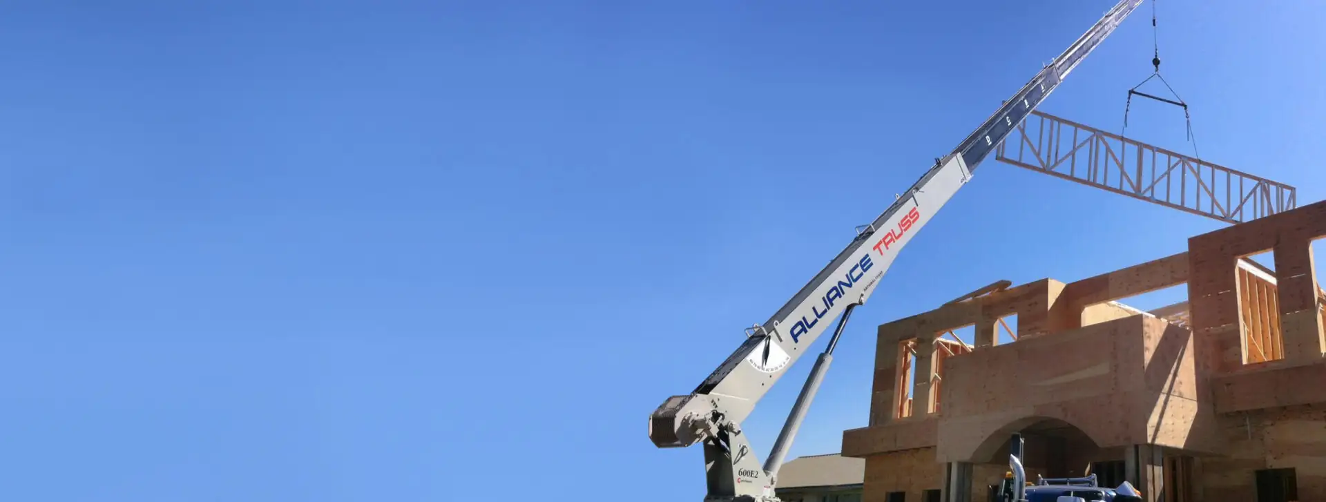 Lifting trusses with crane on a job site