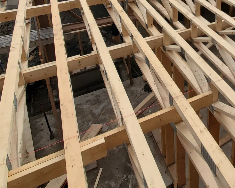Wooden roof rafters and trusses arranged in a radial pattern during construction.