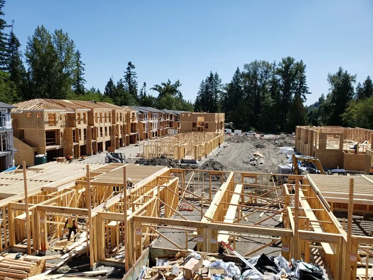 New residential construction site with wooden framing for multiple house structures under development.