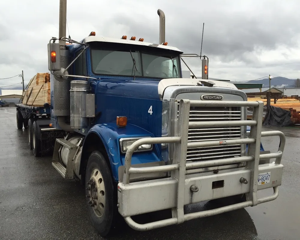 Truck and trailer with full load in yard.